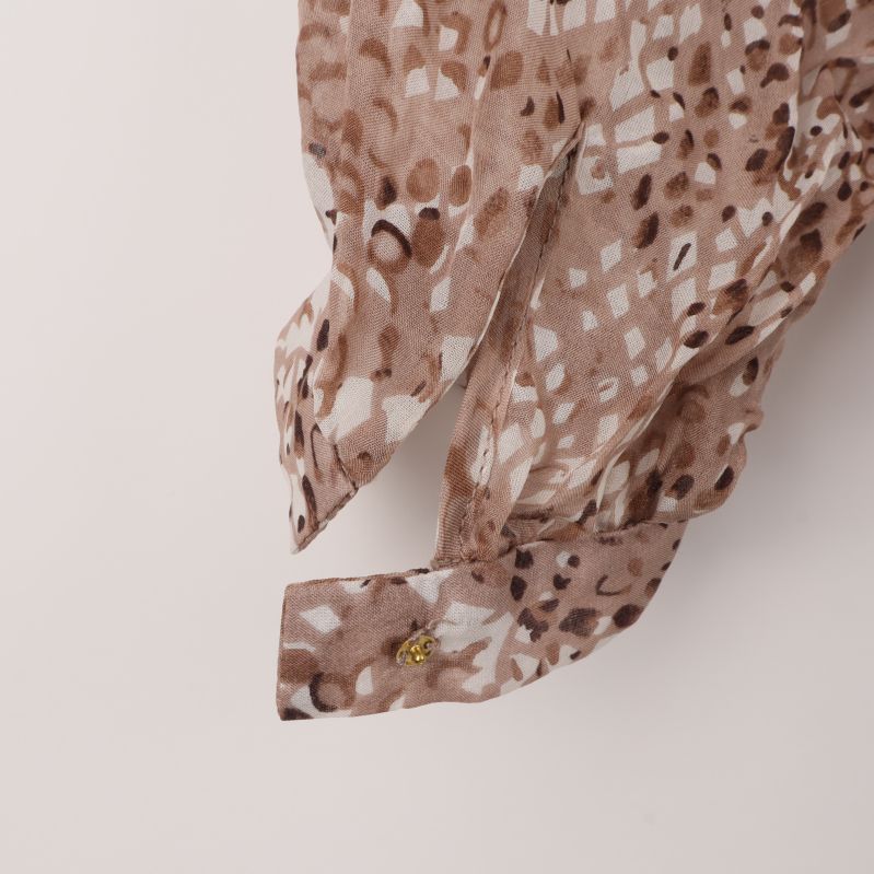 Närbild av ärm och knappdetalj på blus