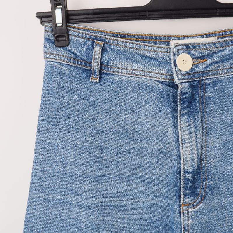 Detaljbild av jeansknapp och midja