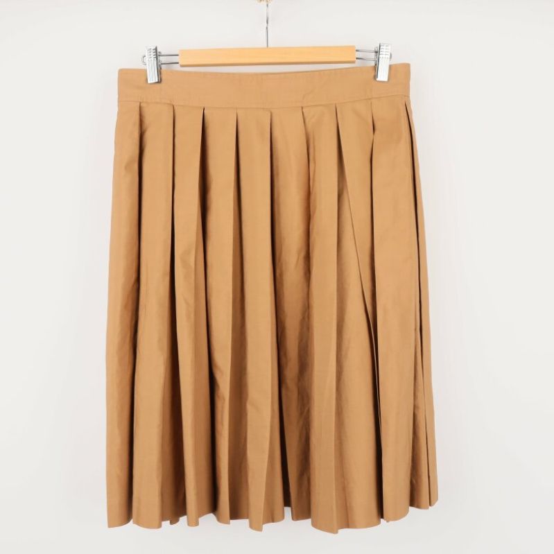 Baksidan av veckad beige kjol på galge