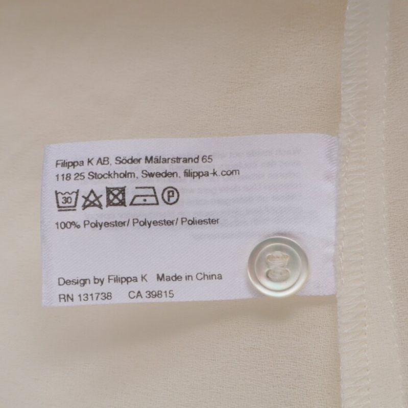 Materialetikett som visar 100% polyester
