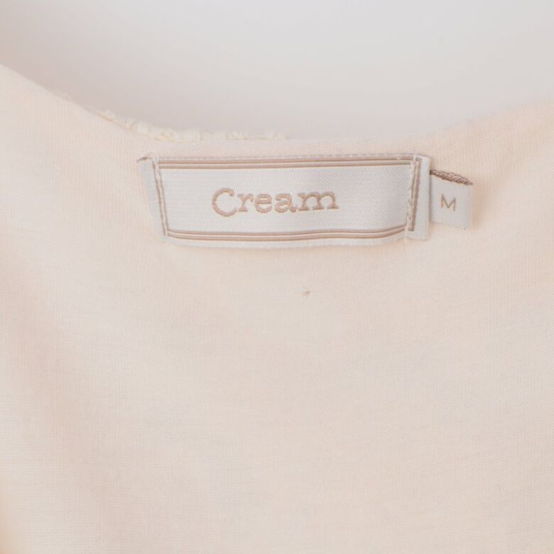 Närbild av Cream etiketten och storlek M