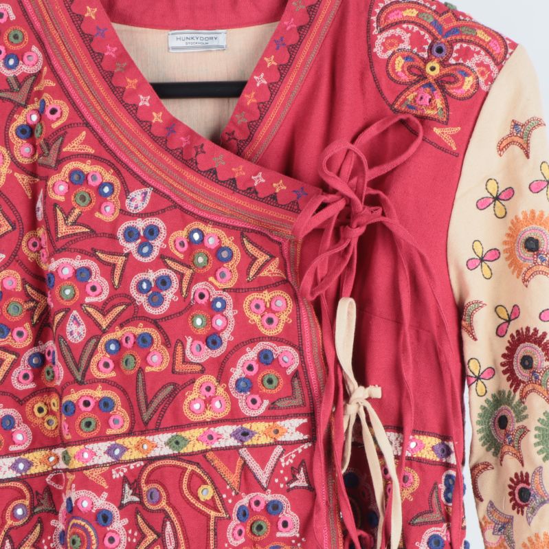 Detaljerat broderi och knytband på bröstet