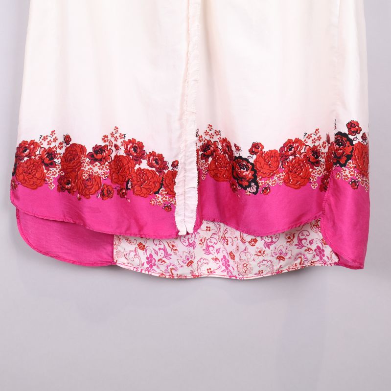 Röd och rosa broderidetalj på kjolens nederdel