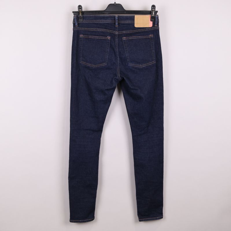 Baksida av mörka jeans med fickor