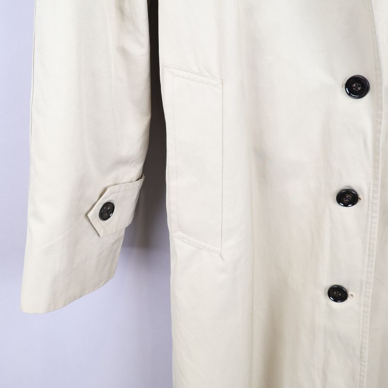 Ärm på beige trenchcoat med knappdetalj