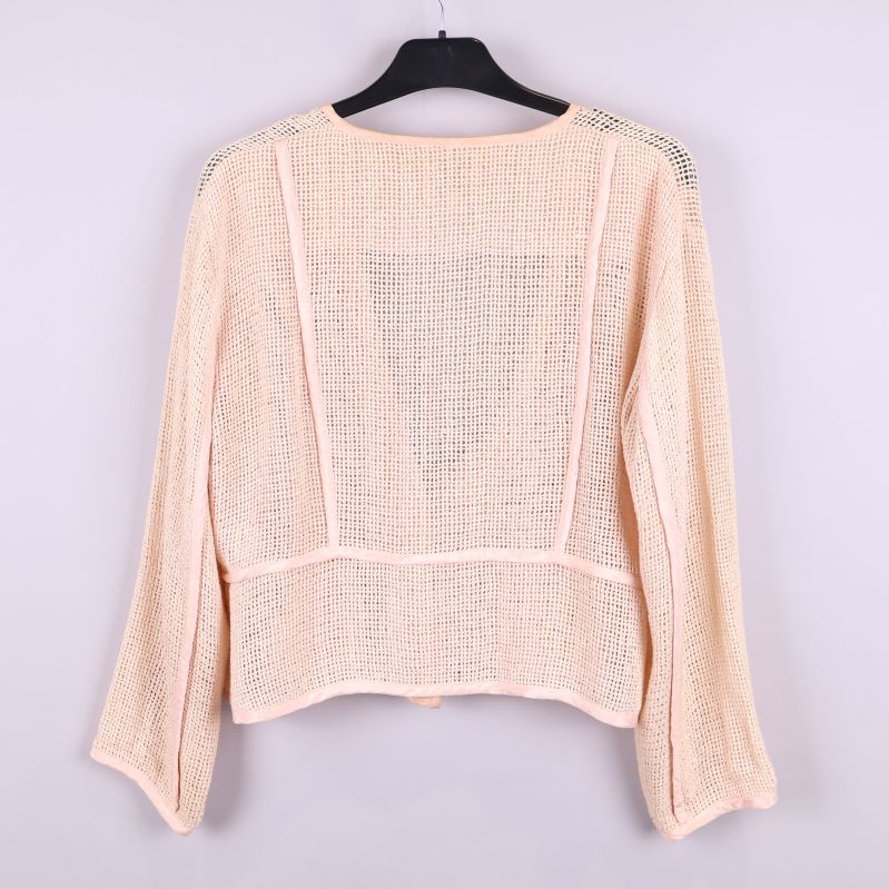 Baksida av beige cardigan med nätmönster