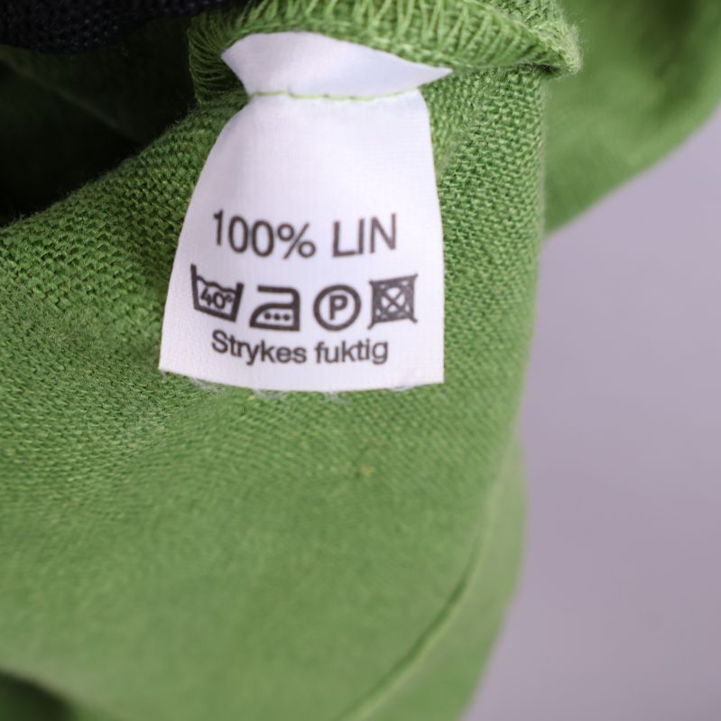 Materialetikett som visar 100% lin