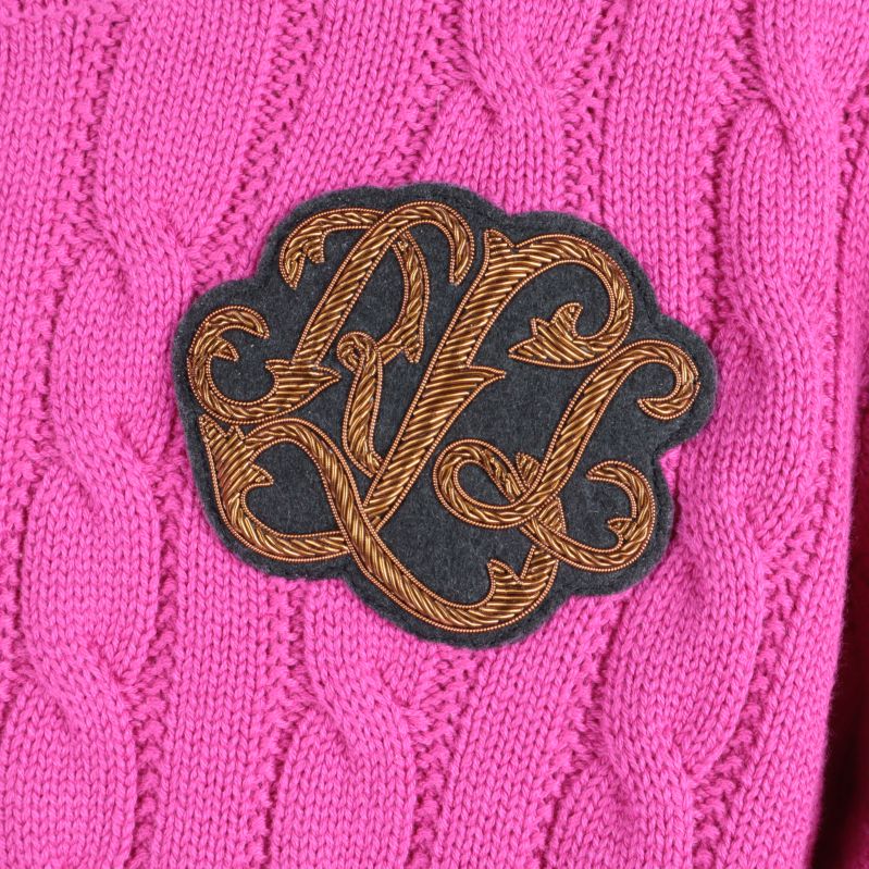 Närbild av monogramdetalj på tröja