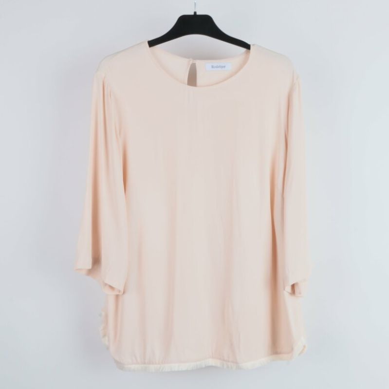 Framifrån av beige blus med rund halslinning