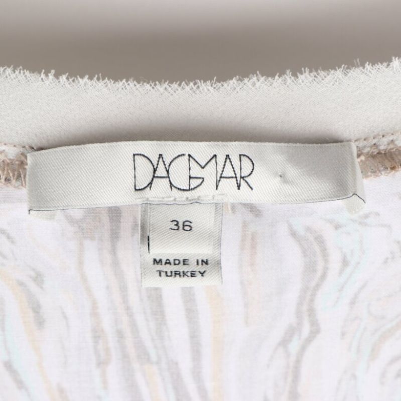 Närbild av klädtagg med märket: Dagmar, storlek 36