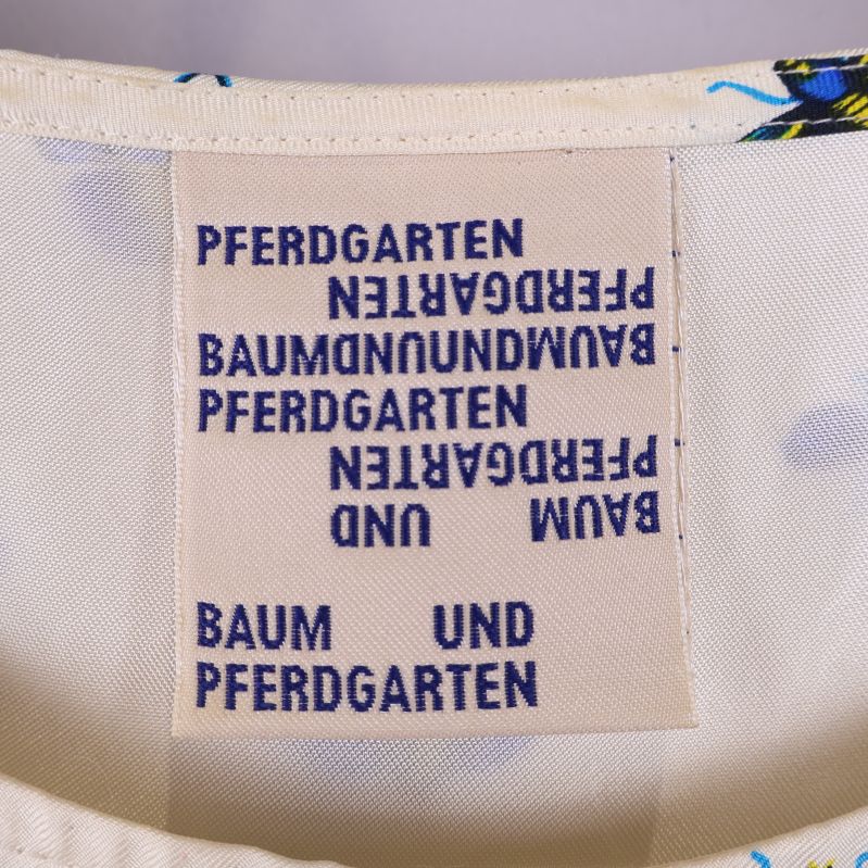 Materialetikett för blus visar 100% siden