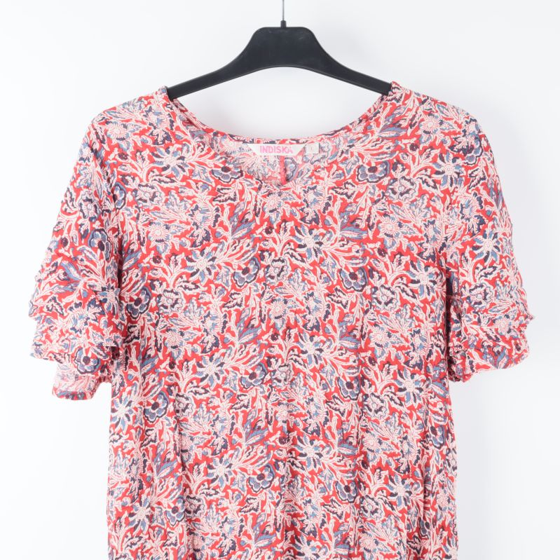 Närbild av klänningens blommiga mönster på byst