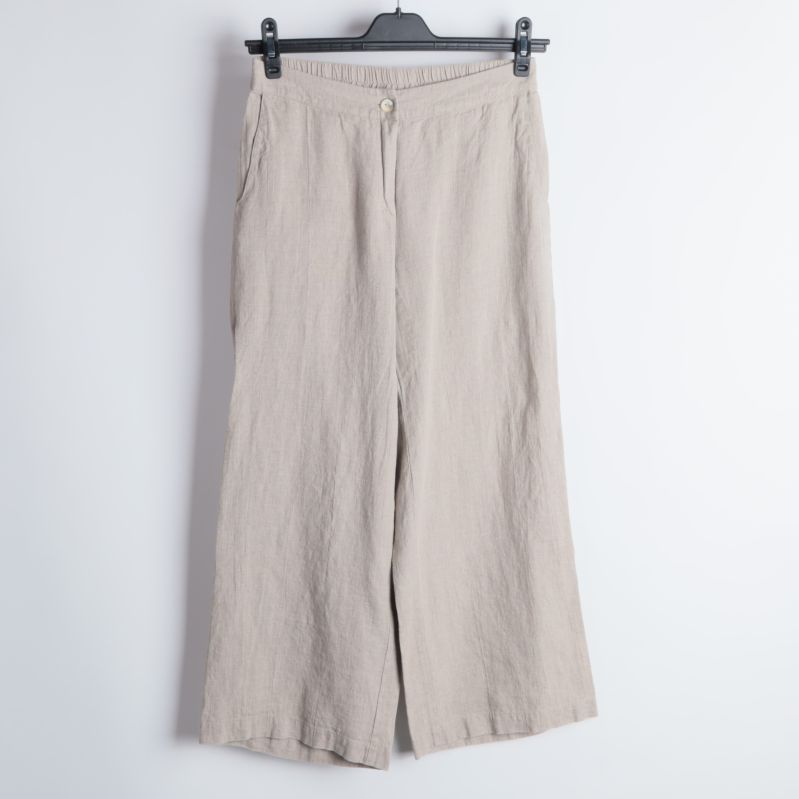 Främre delen av beige byxor med knapp.