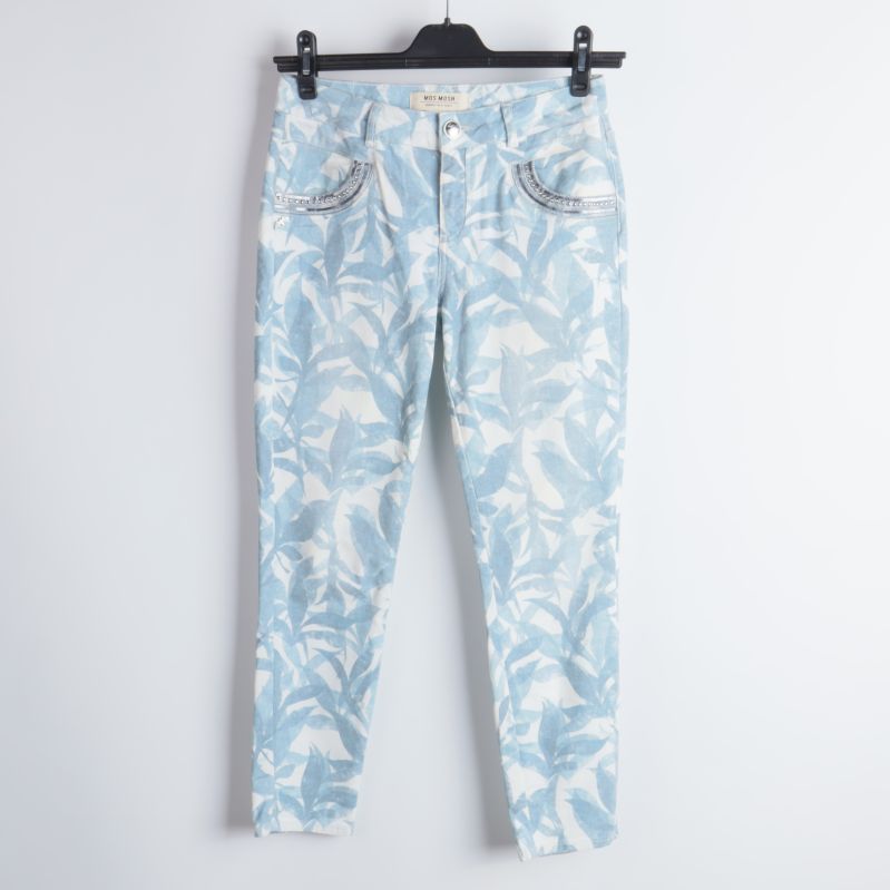 Blommiga jeans hänger på galge