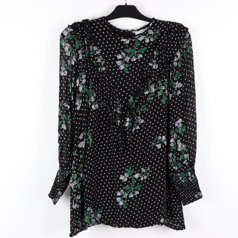 Blus med vitprickigt och blommigt mönster framifrån