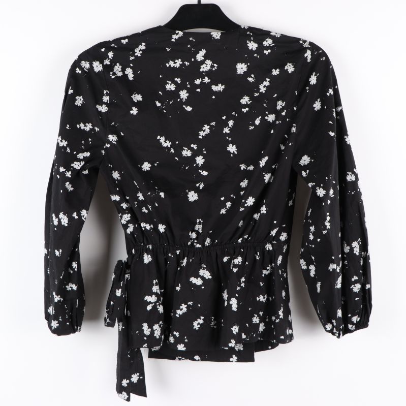 Svart blus med vitt blommönster bakifrån