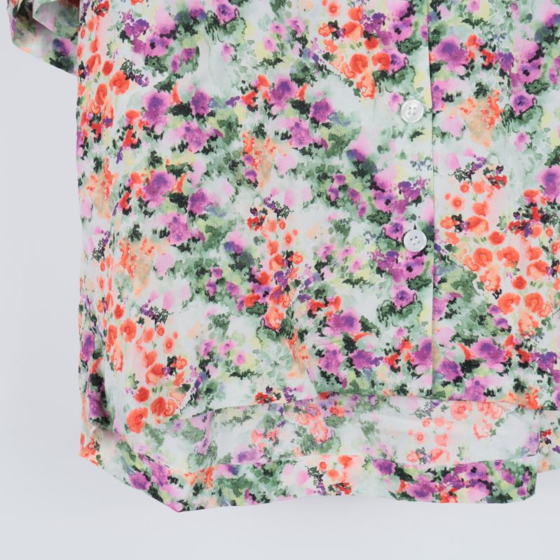 Närbild på nedre del av blus med blommigt mönster