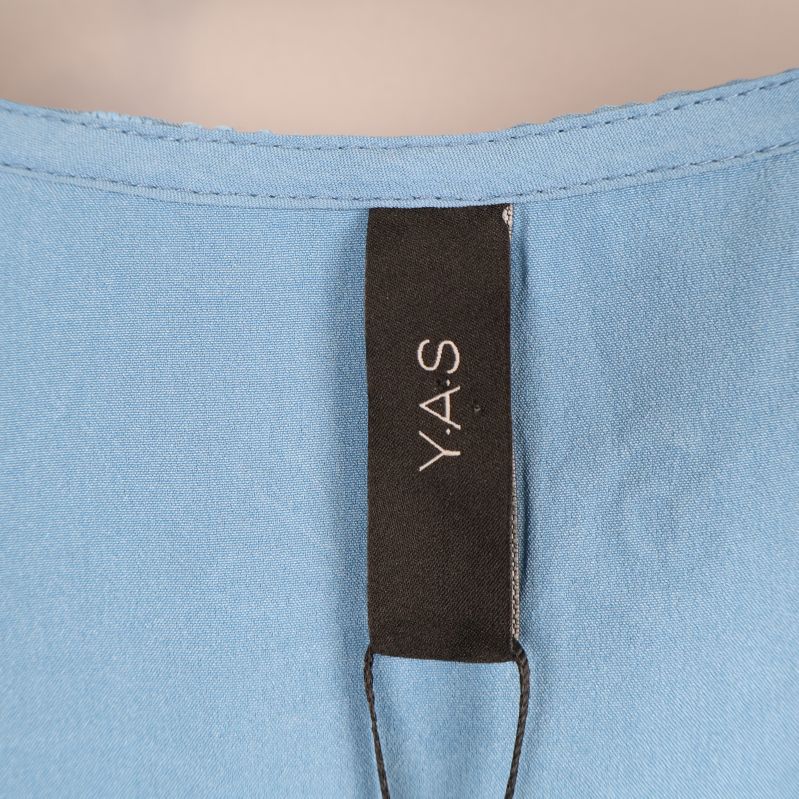 Märkesetikett med Y.A.S logga på blå byxdress