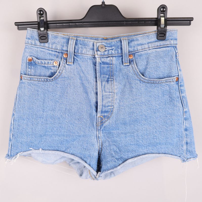 Framsidan av ljusblå jeansshorts på galge
