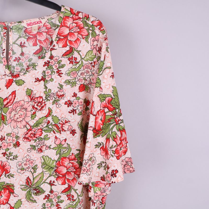 Närbild av klänningens blommiga mönster och ärmdetaljer