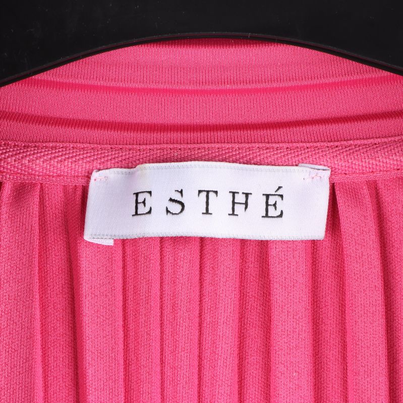 Etikett med texten ESTHÉ på plisserad skjorta
