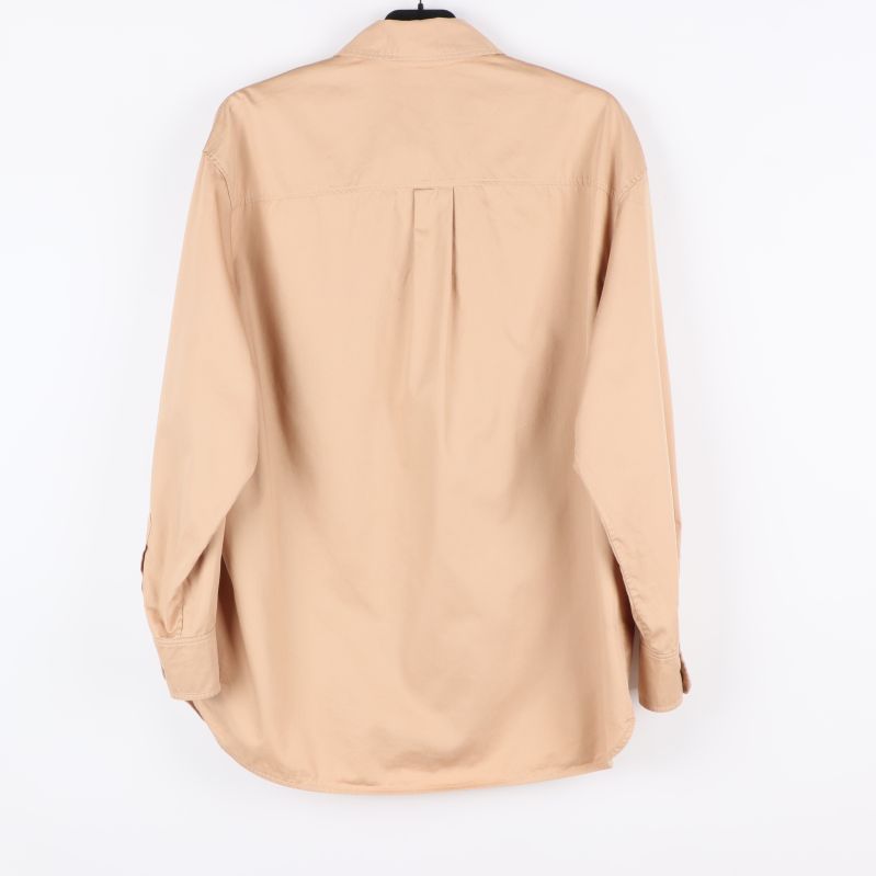 Baksidan av beige skjorta med veck därbak