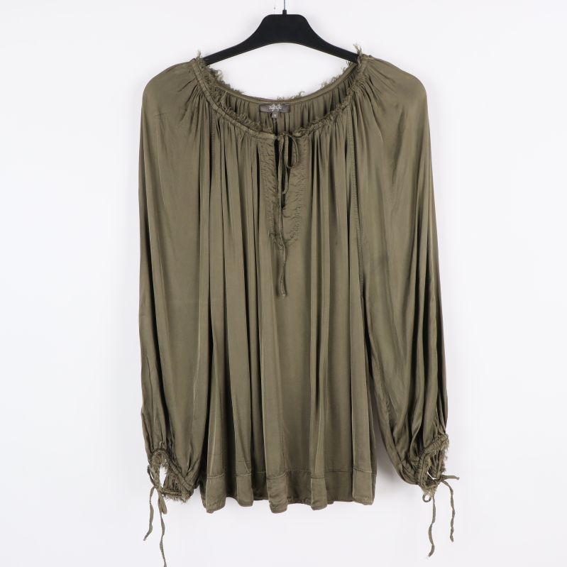 Framifrån av grön blus med veckdetaljer