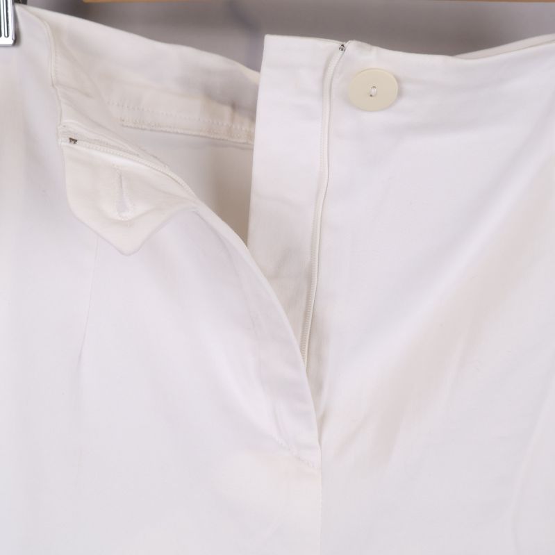Öppen knäppning på vita byxorna