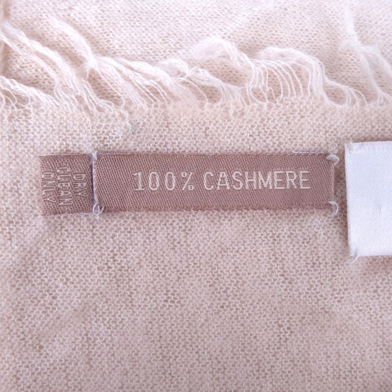 Etikett med texten 100% CASHMERE på beige cashmere halsduk
