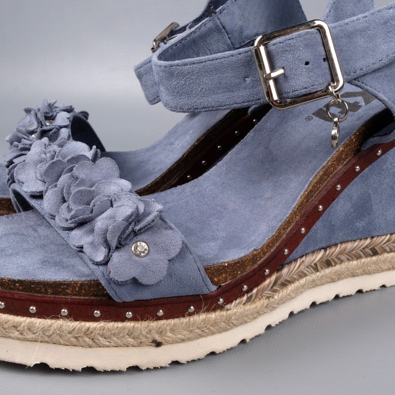 Närbild på blommor och material på sandal