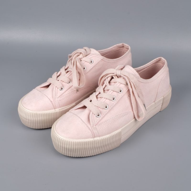Framsida av ljusrosa sneakers med snören och platåsula