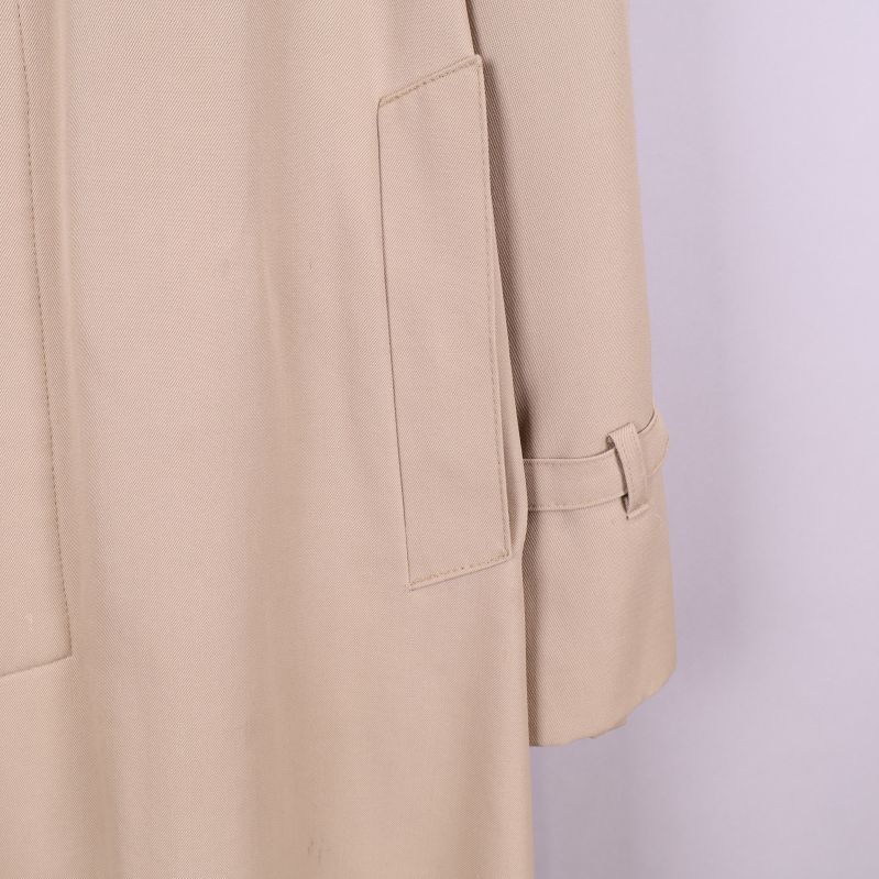 Närbild av trenchcoat ficka och ärm