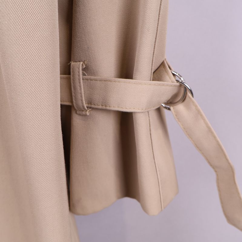 Detail av ärmrem på trenchcoat