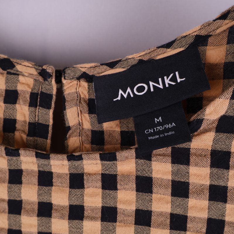 Närbild på Monki etikett och storlek M i klänningen
