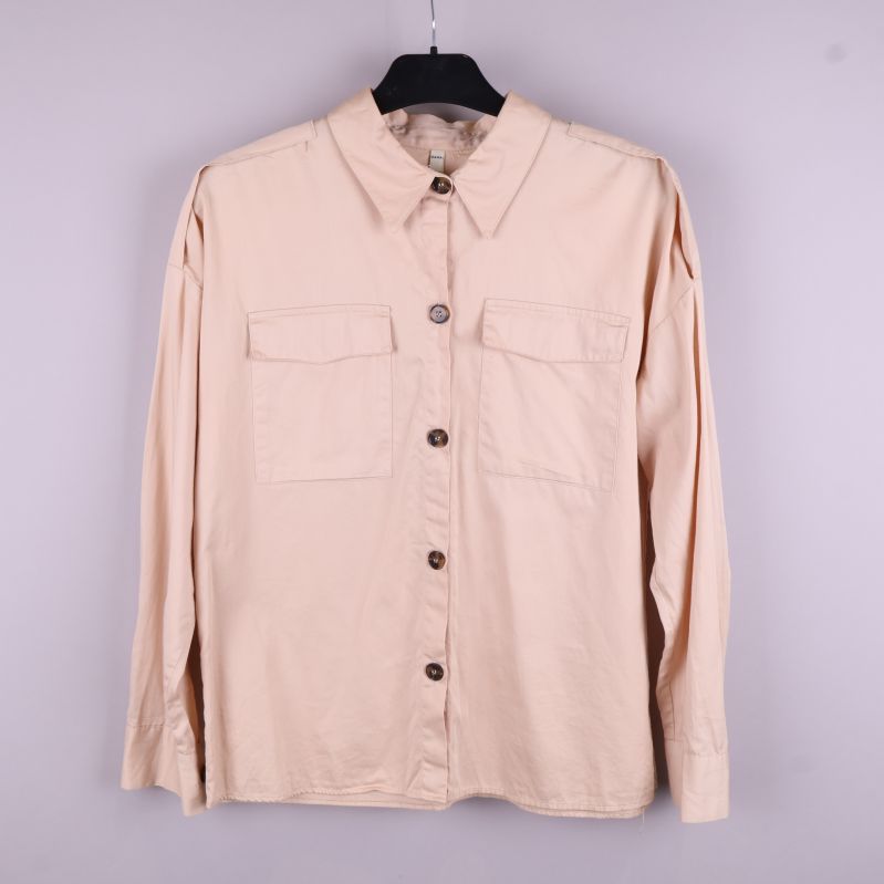 Beige skjorta framifrån med knappar och fickor