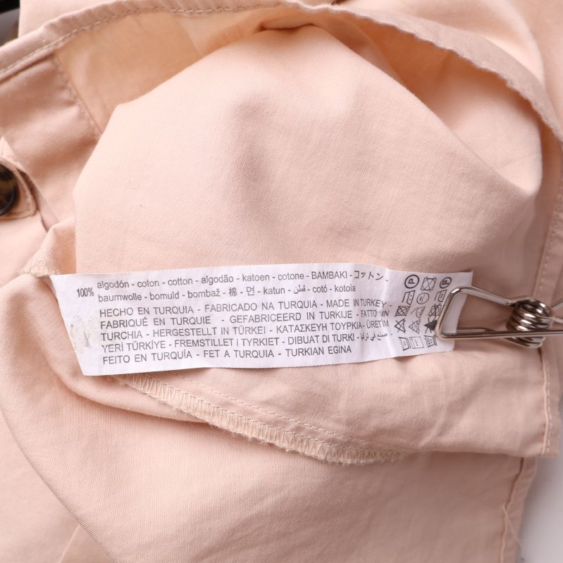 Materialetikett på beige skjorta