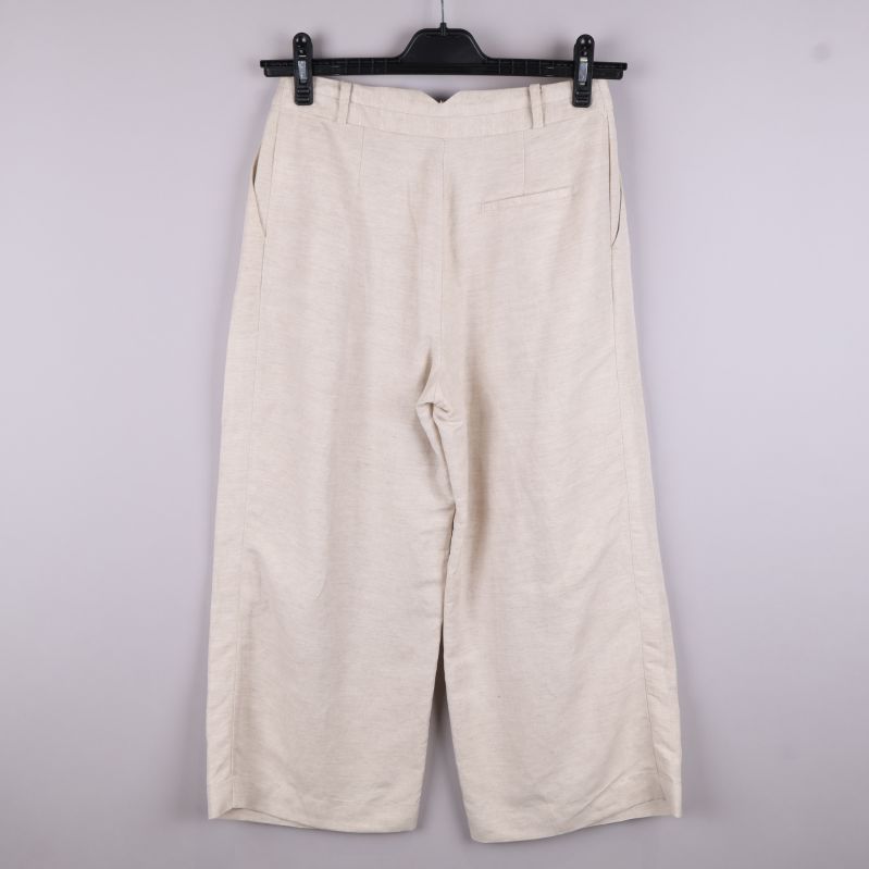 Beige byxor bakifrån på galge
