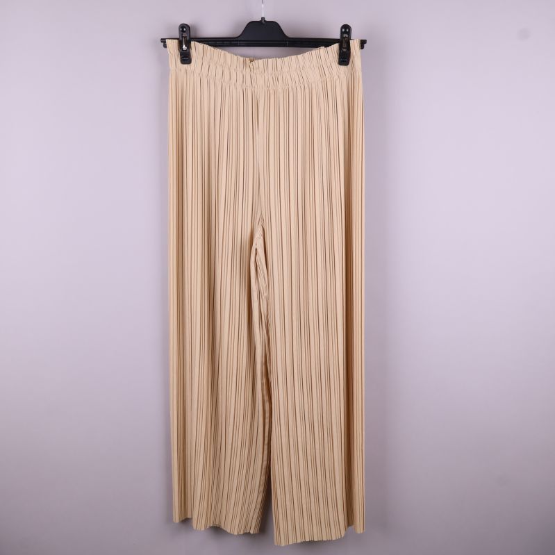Beige plisserade byxor hängande framifrån