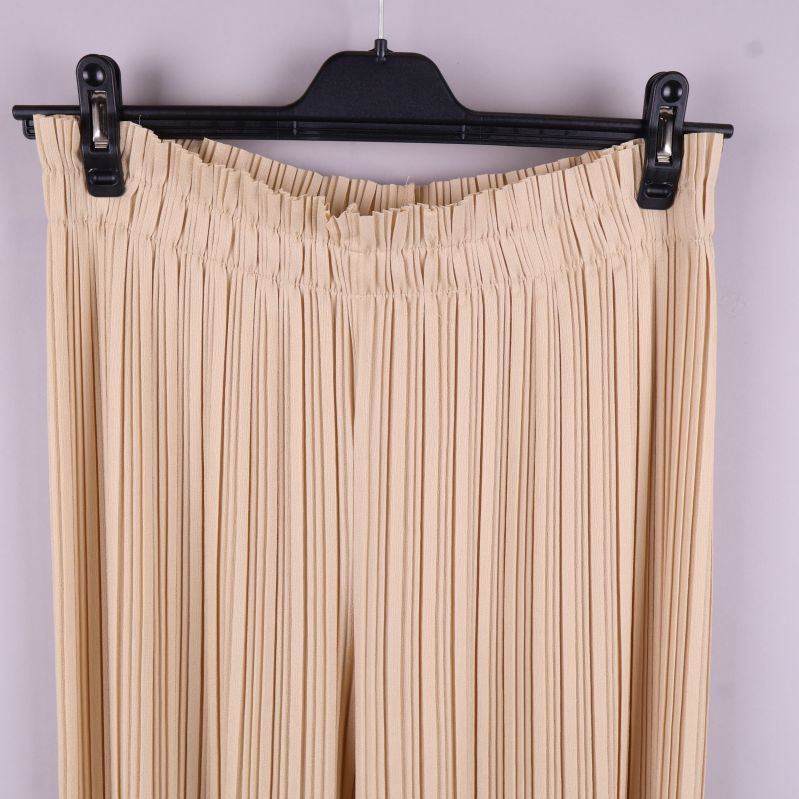 Närbild av resårmidjan på de beige byxorna
