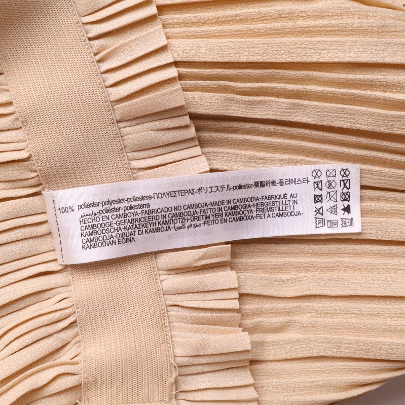Materialetikett på de beige byxorna