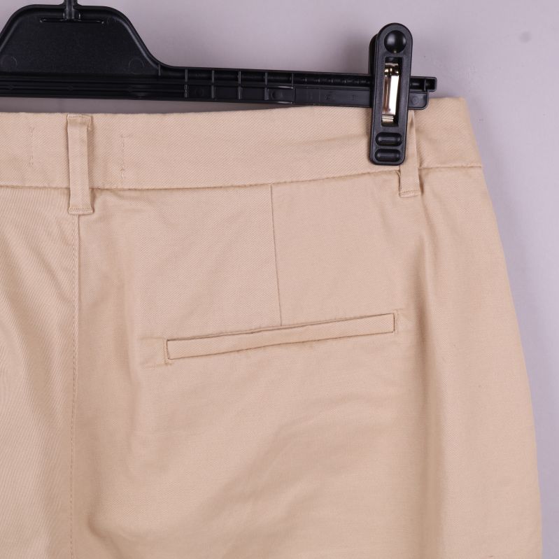 Baksida av ficka på beige shorts