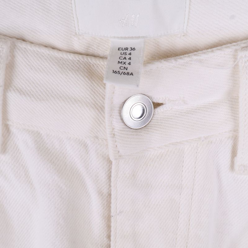 Storleksetikett i jeans, visar EU-storlek 36