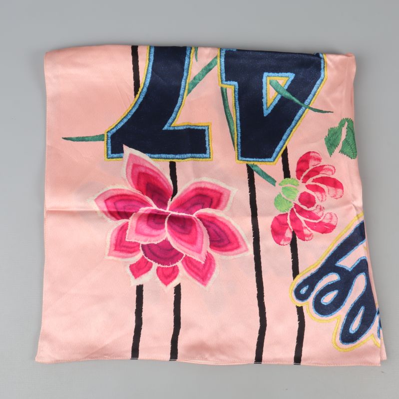 Närbild på scarfens blommönster med text