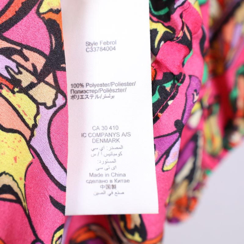 Materialetikett på tunika med polyesterinformation