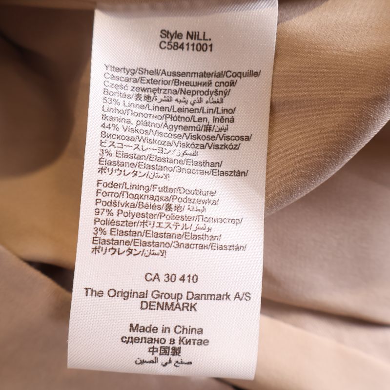 Materialetikett på insidan av ljus beige kavaj