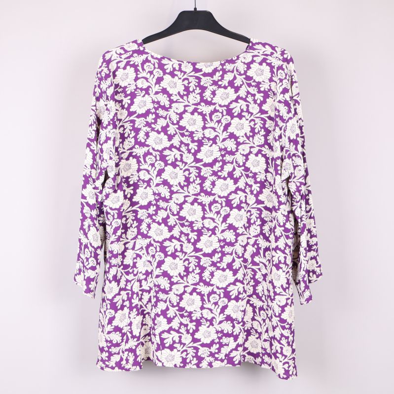 Lila och vit blus med blommönster bak