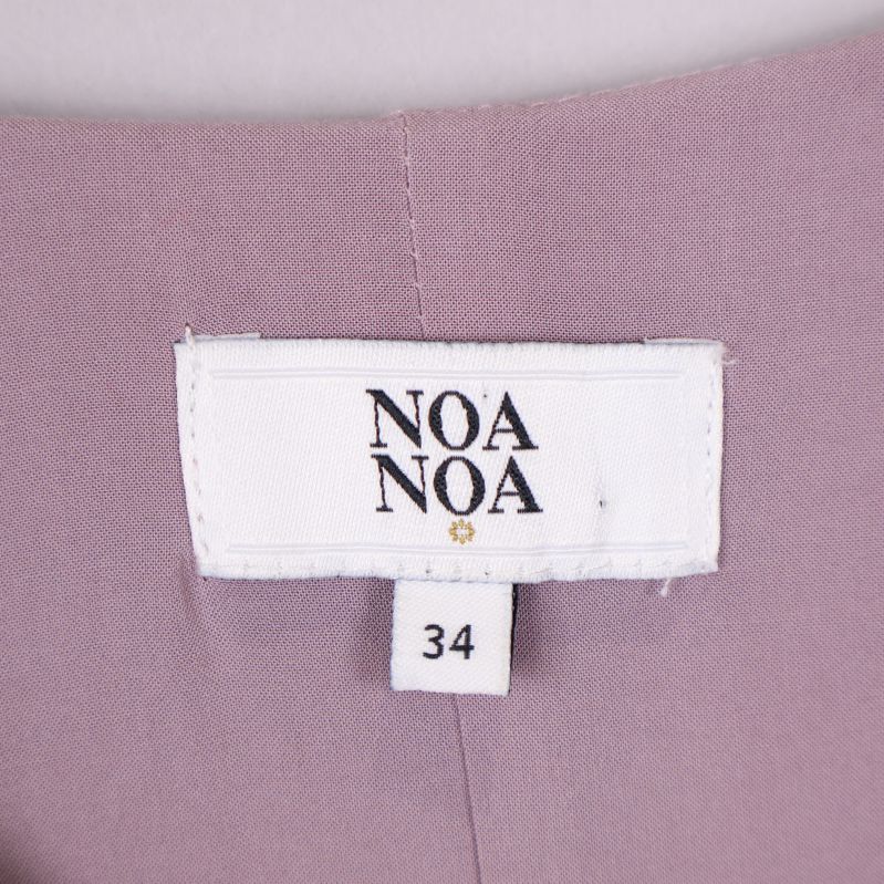Vit etikett med Noa Noa logotyp