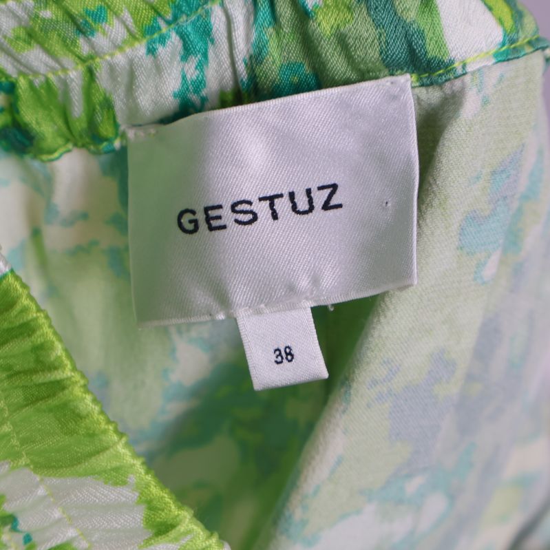 Märkesetikett med Gestuz och storlek 38