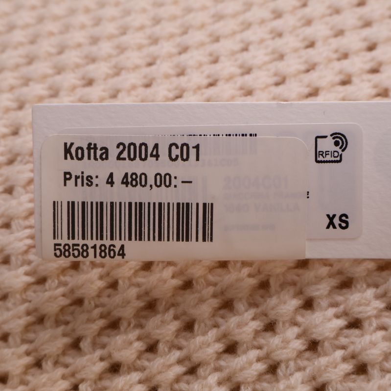 Pris- och storlekslapp på koftan