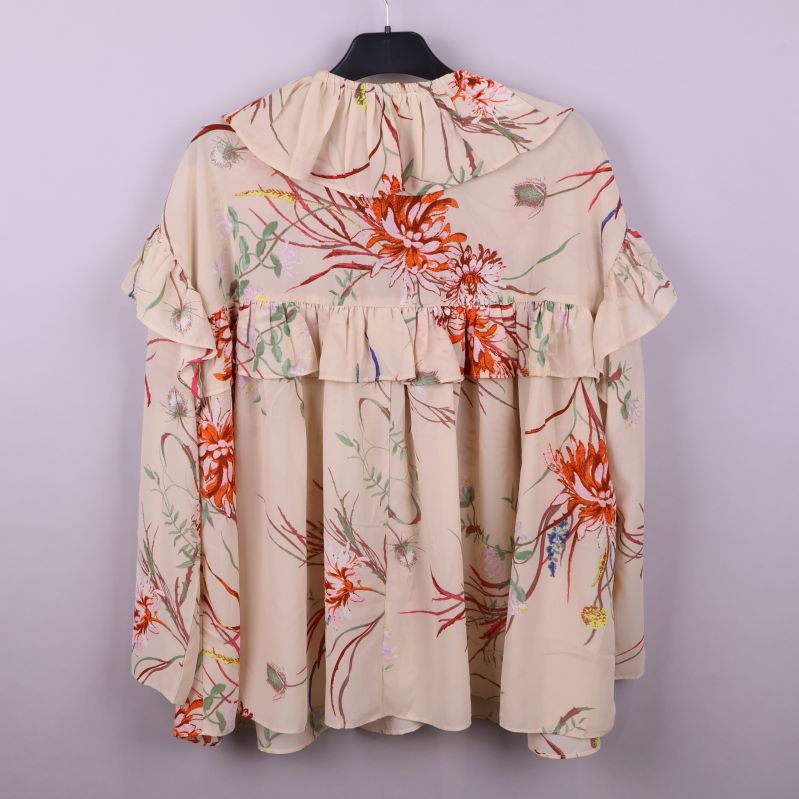 Baksidan av blommig blus med volanger